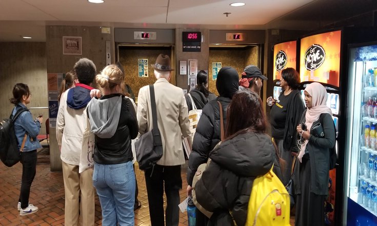Students and faculty linger while main elevators are out of service following the most recent evacuation drill.